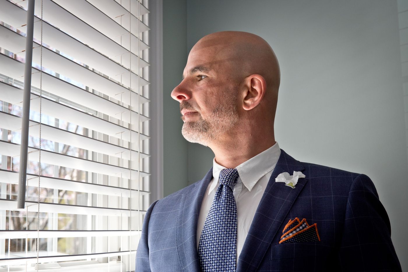 Chris in a suit, looking out a window